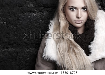 Beautiful Blond Woman In A Fur Near Bricks Wall. Winter Fashion. Your Text Here. Long Hair