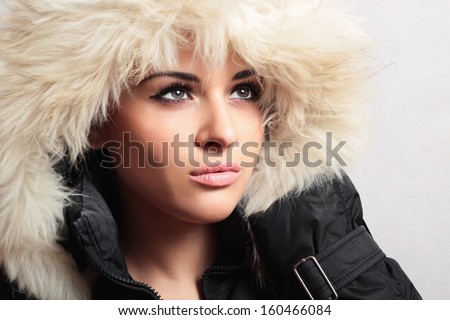 Fashion portrait of young beautiful woman with fur. white fur hood. winter style. make-up