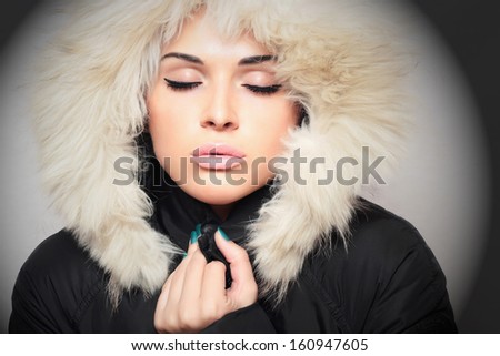 beautiful woman with fur. white fur hood. winter style.make-up. fashionable girl