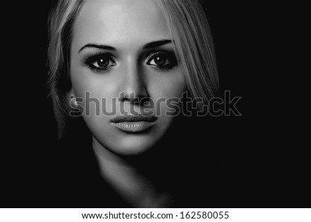 art portrait of beautiful blond woman. black background.monochrome