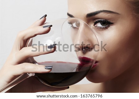 Beautiful blond woman drinking red wine.make-up.red lips.wineglass