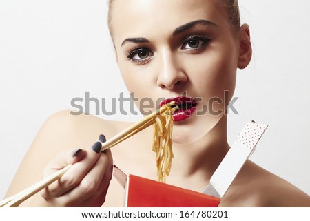 beautiful woman are eating noodles.red lips.Chinese sticks. food