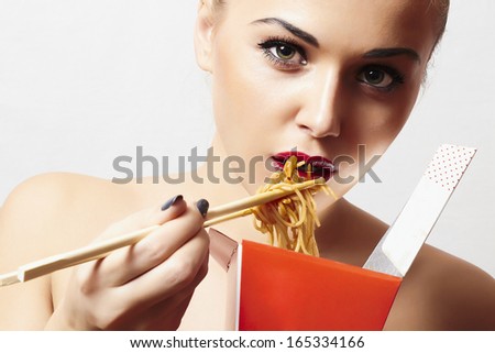 Beautiful woman are eating noodles.red lips.Chinese sticks. fast food.food delivery