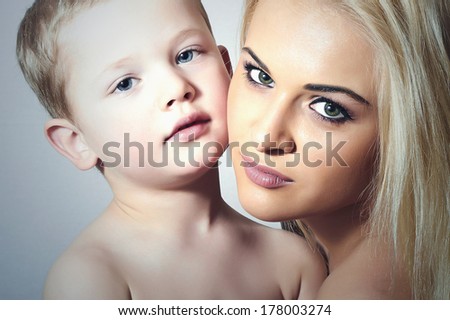 Young Mother Hugging Child. Beautiful Blond Woman with Little Son. Happy Beautiful Family