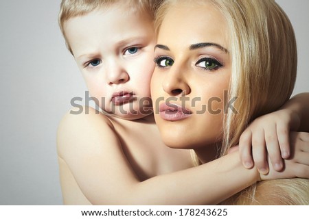Young Beautiful Mother Hugging Child. Blond Woman with Little Son. Happy Family