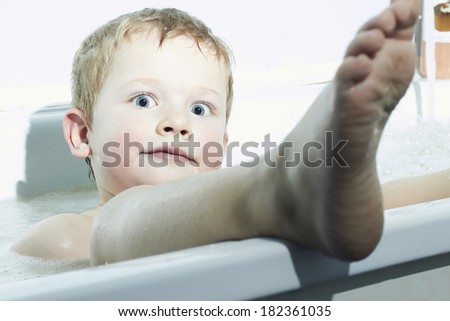 Smiling Little Boy in the Bath.Funny Child in Foam. Blue Eyes