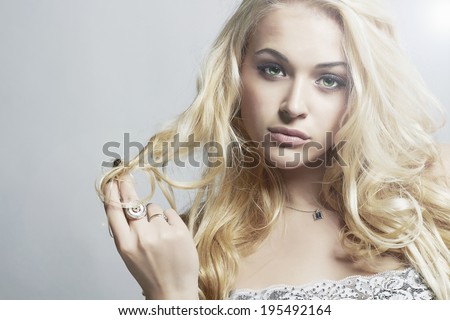 Close-up fashion portrait of Beautiful woman.Flirt Blond Girl with Curly hair.Light.Gray background