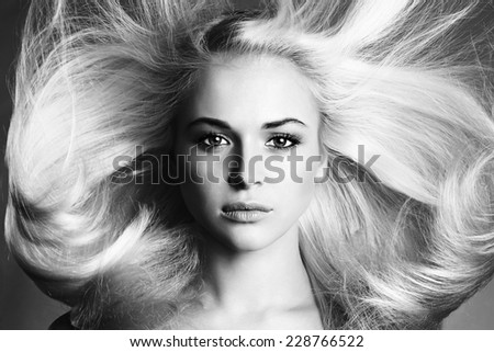 Beautiful Face of Young Woman.Blond girl.close-up.Art monochrome portrait.Beautiful healthy hair.Beauty salon.flying hair