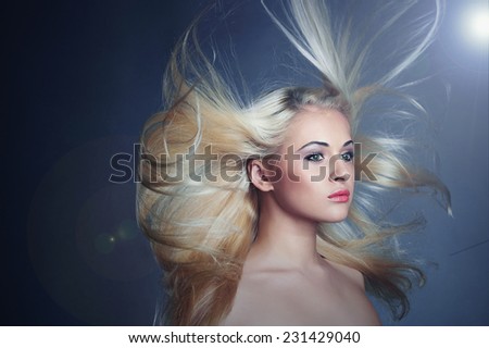 beautiful blond woman in dark. Sexy girl.healthy hair.Beauty salon.flying hair