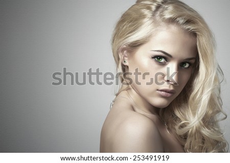 young beautiful woman.Sexy Blond girl. Gray Background.Your text here.Hairstyle