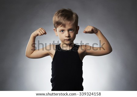 Child. Funny Little Boy.Sport Handsome Boy.bodybuilder showing his hand biceps muscles