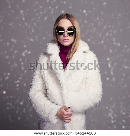 beautiful winter style girl in white fur and sunglasses. fashion beauty young snow woman
