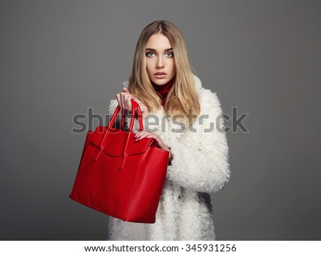 Winter beautiful Woman with red Handbag.Beauty Fashion Girl in fur. luxury stylish blonde.Shopping
