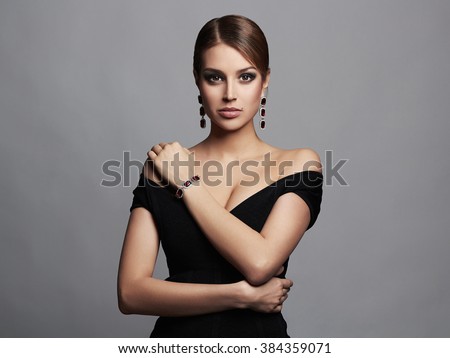 fashion portrait of young beautiful sexy woman in jewelry.Beauty girl with short hair and make-up.elegant lady in black dress