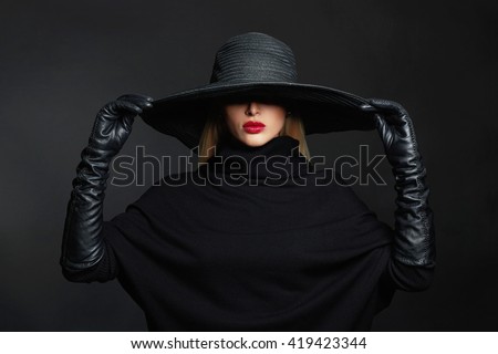 Beautiful woman in hat and leather gloves. Retro fashion model girl.black hat with large brim.halloween witch