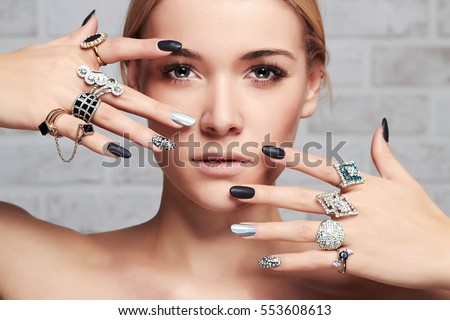 beauty face.woman\'s hands with jewelry rings.close-up beauty and fashion portrait. girl make-up and manicure