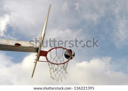 basket ball board under blue sky with white clouds and ball