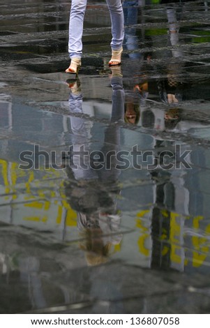 woman reflection in the water after the rain