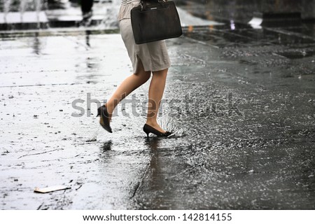 female feet with heels shoes walk on water when it rains