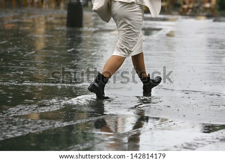female feet with heels shoes walk on water when it rains