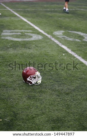 American Football Helmet on the Field with 50 yard line