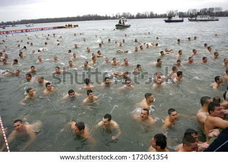 ZEMUN, SERBIA - JAN 19, 2014: Participants swim in the river. The Serbian Orthodox Church, traditionally marks Epiphany with competitions to retrieve the Holy Cross from Danube river in Zemun quay