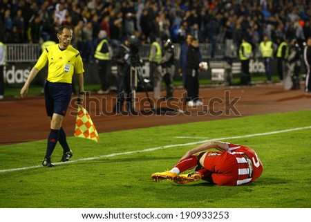 SERBIA, BELGRADE - APRIL 27, 2014: The referee looks at the injured Mijailovic. Eternal rivals have met 146th times in the Eternal soccer derby, Partizan and Red Star from Belgrade, played on 27 April