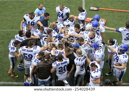 Belgrade, Serbia - May 05, 2014: Team Blue Dragon in the common embrace. American Football Match Between Belgrade Wolves And Blue Dragon in Belgrade. The Wolves team is winner.