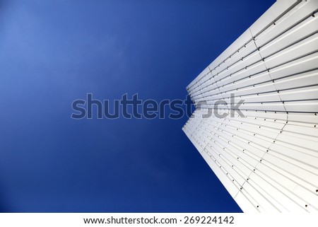 Architectural Detail of steel metal on right side a modern geometry with blue sky background with copy space