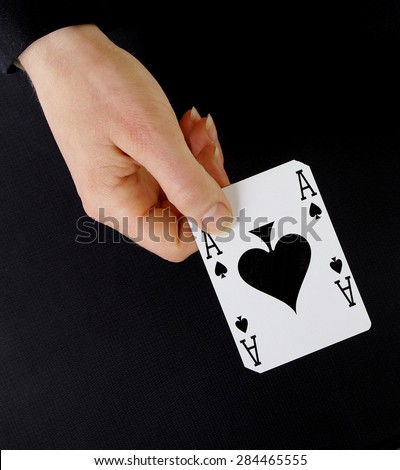 croupier player holding in hand card ace of spades on black background