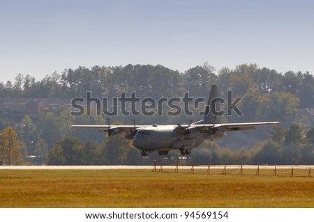 Modern air force cargo jet landing at dawn