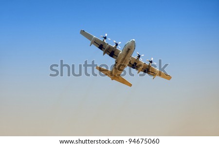 Modern military cargo airplane taking off at dawn