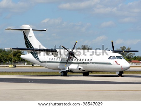 White turboprop airplane parked on a tarmac