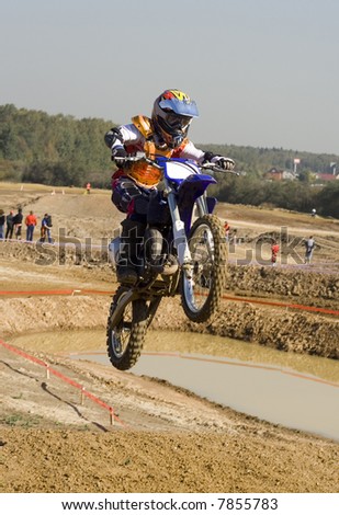 Young motocross rider jumping at finish line