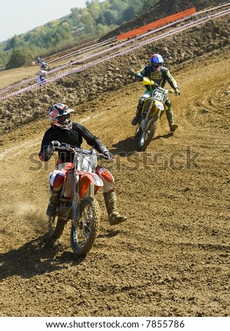 Two motocross riders duelling at turning point