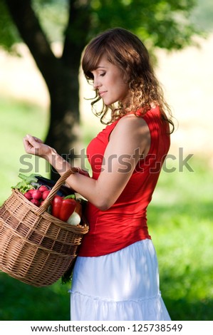 Young woman with basket filled fresh vegetable