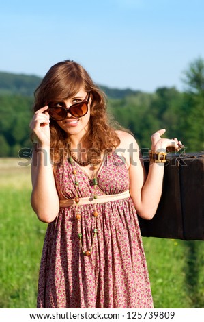 Young woman looking behind sunglasses