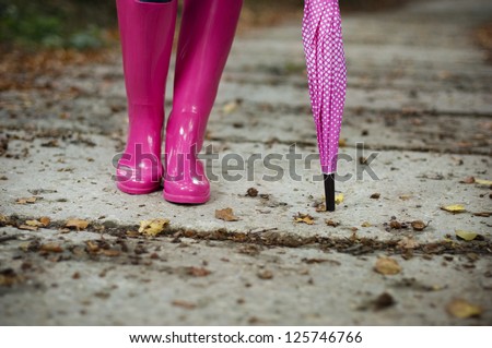 Woman with umbrella wearing rubber boots