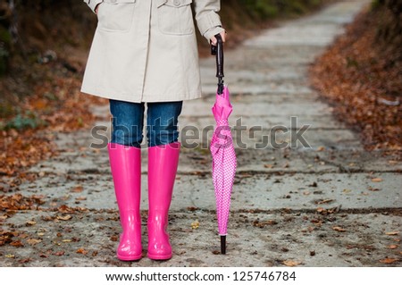 Woman with umbrella wearing rubber boots