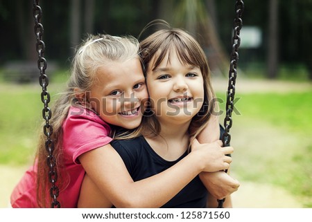 Best friends swinging in a park