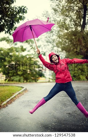 Cheerful woman jumping with umbrella