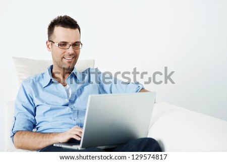 Handsome Man In Glasses Using Laptop On Sofa