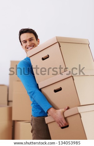 Handsome man carrying stack of boxes
