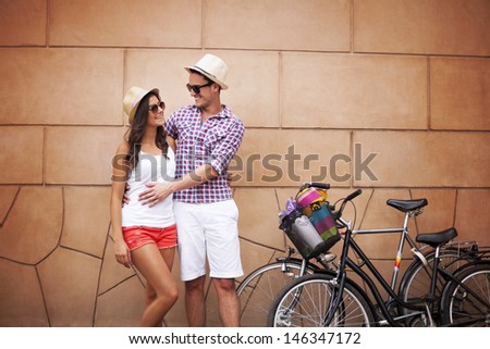 Young couple standing against the wall and hugging