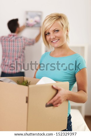 Woman carrying box with items for a new apartment