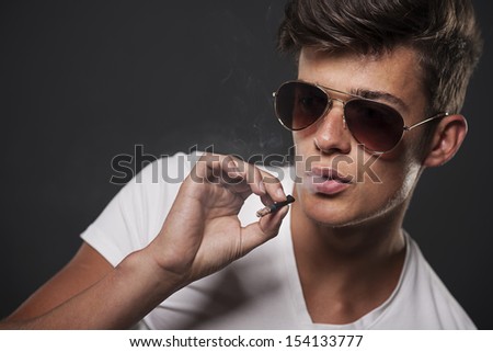 Stylish young man smoking cigarette