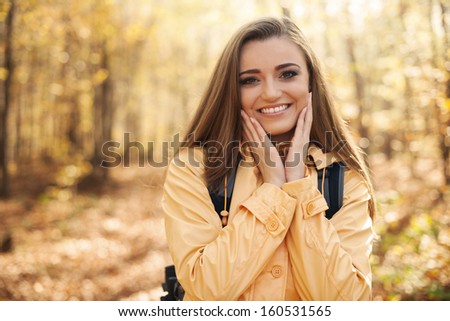Portrait of young happy woman during the autumn hiking