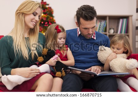 Dad reading book for his daughters in christmas