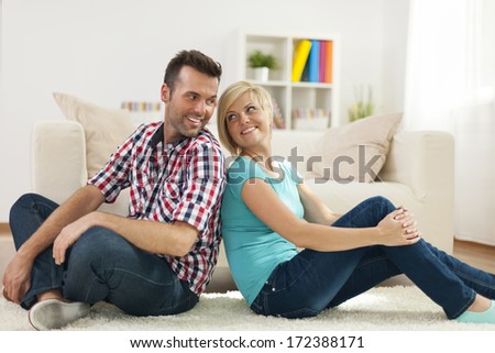 Loving couple sitting on carpet at home