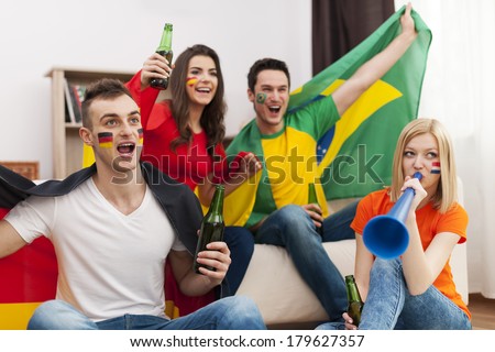 Multi ethnic group of people cheering football match